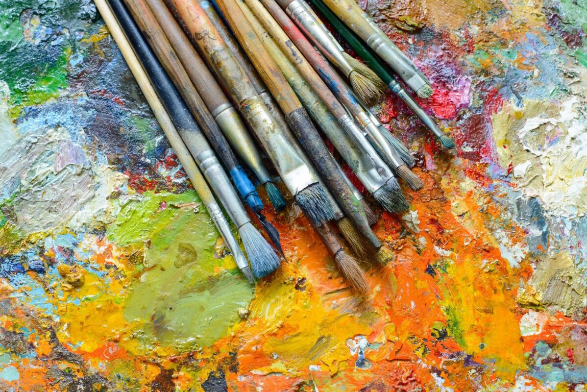 Fine Art Paint Brushes on a paint filled palette from the website of Artist Priscilla Prentice